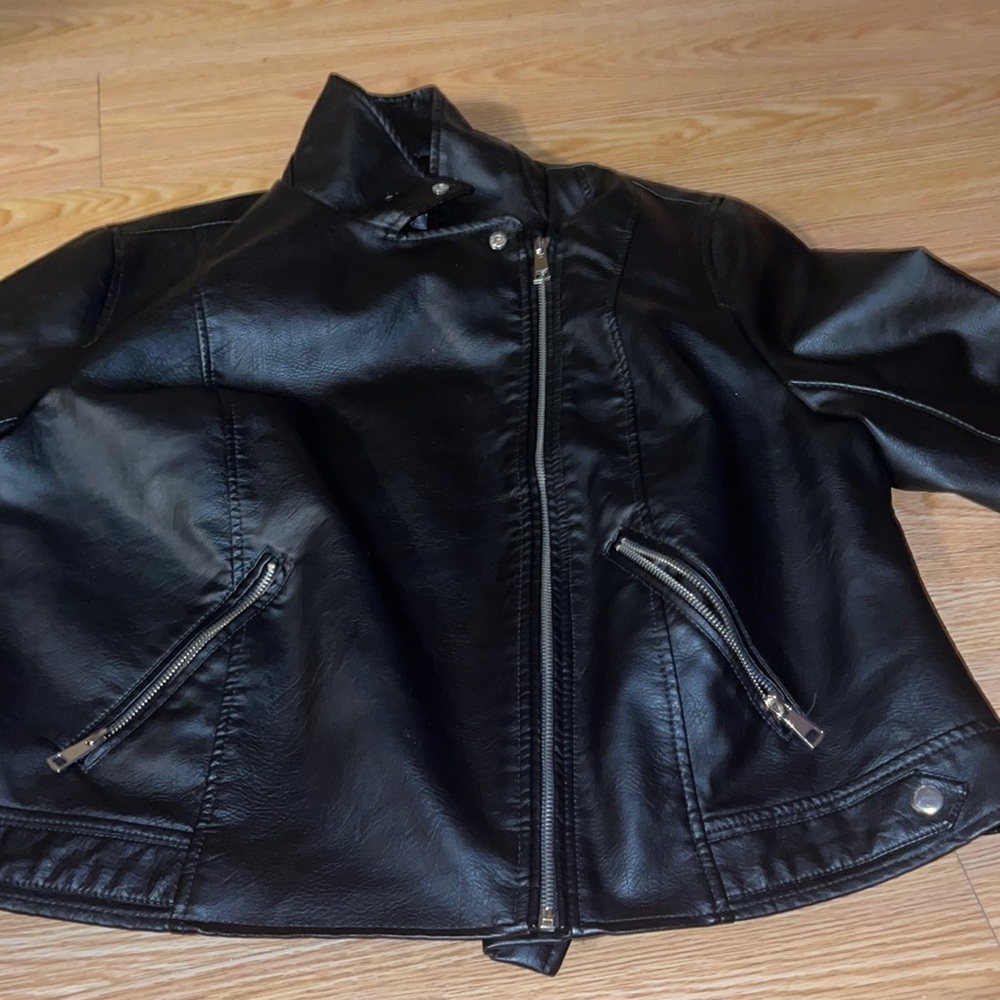 It’s a real leather jacket with two pockets long sleeves buttons and comfortable